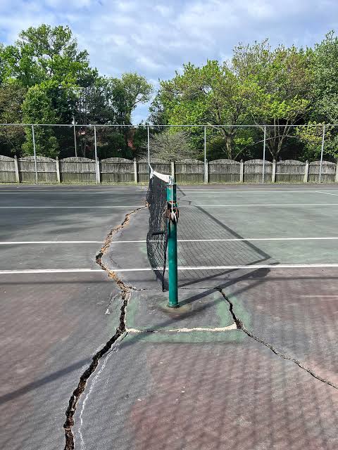 Cracked pickleball court surface before resurfacing