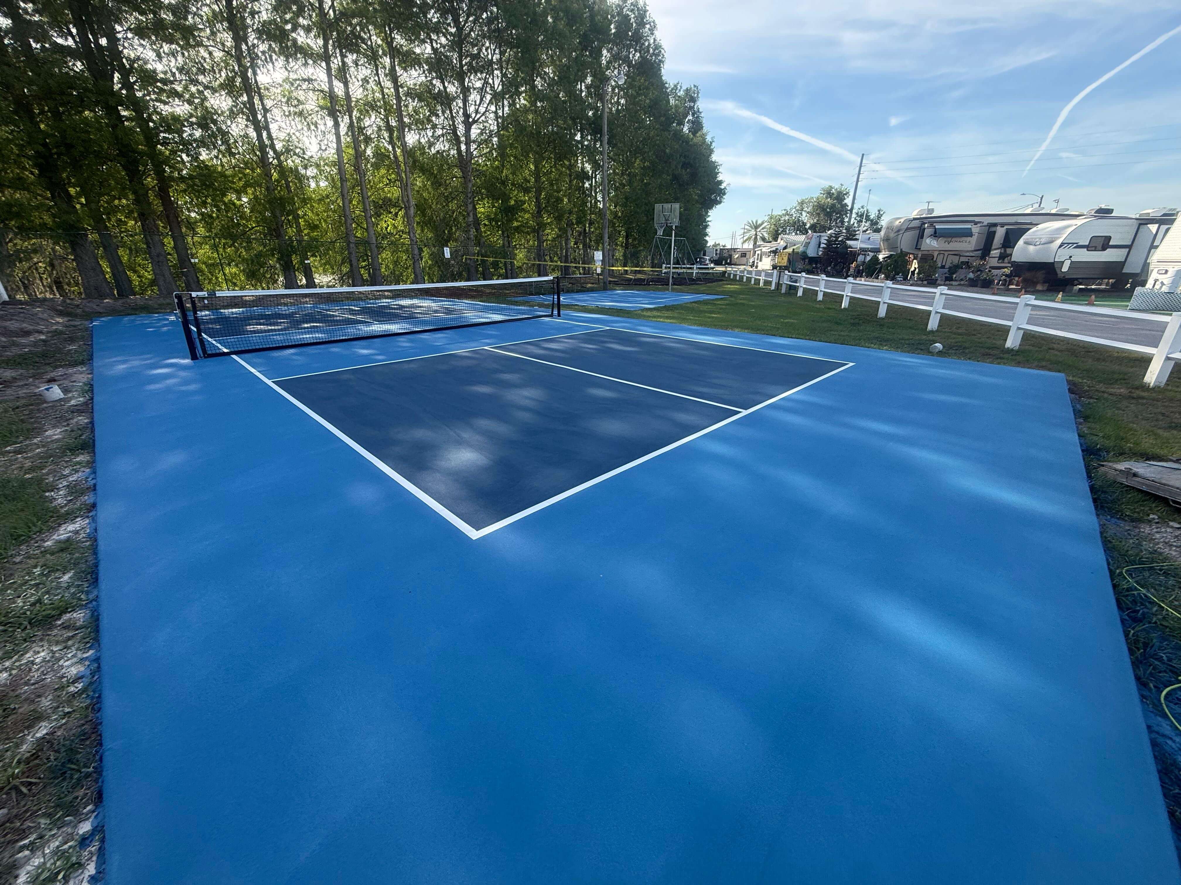 Pickleball court at an RV park with RVs parked nearby
