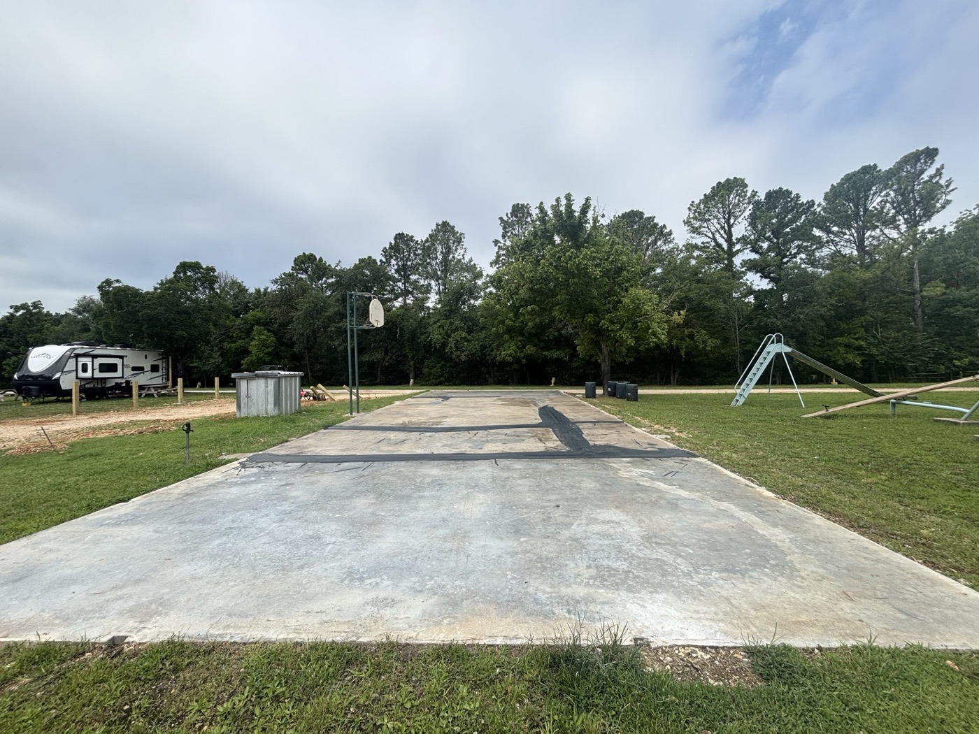 Cracked, worn RV park slab before pickleball court resurfacing
